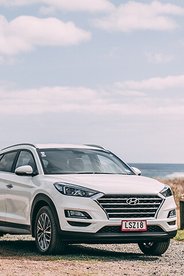 Close up image of a new Hyundai Santa Fe rental car with pink GO Rentals plates
