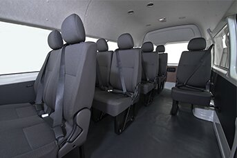 Rear interior image of a Toyota Hiace 12-seater minibus showing the backseats