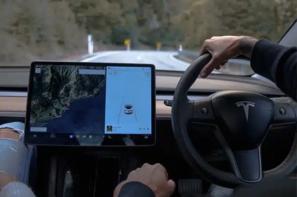 Interior view of a Tesla showing the touchscreen navigation while driving