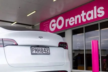 Rear view of a white Tesla Model Y parked at GO Rentals