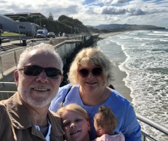 Julie with her family beside the ocean beach