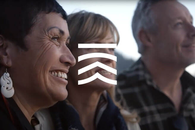 Image of a people smiling with the tiaki promise icon overlayed